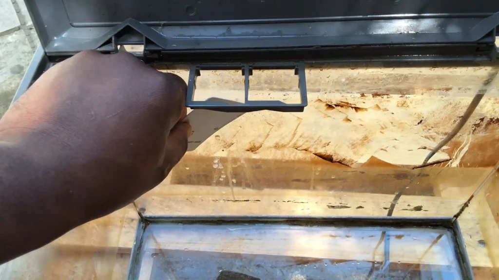 Grattage du calcaire avec une carte plastique rigide pour éviter de rayer le verre